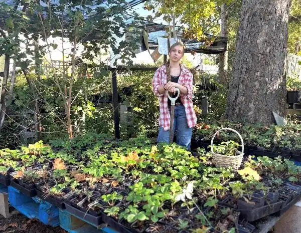 girl standing in garden with shovel